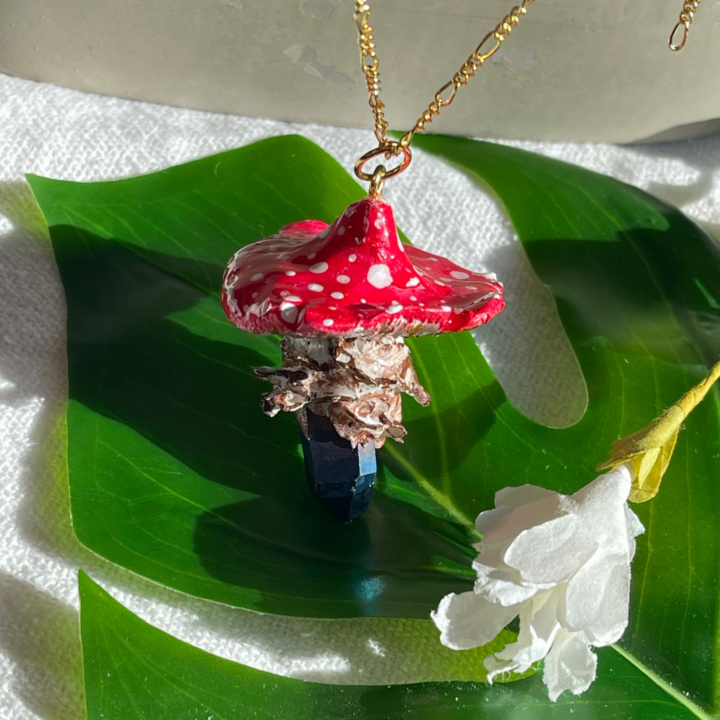 Handcrafted necklace featuring a blue quartz crystal and a polymer clay mushroom pendant, perfect for bohemian and nature-inspired fashion.