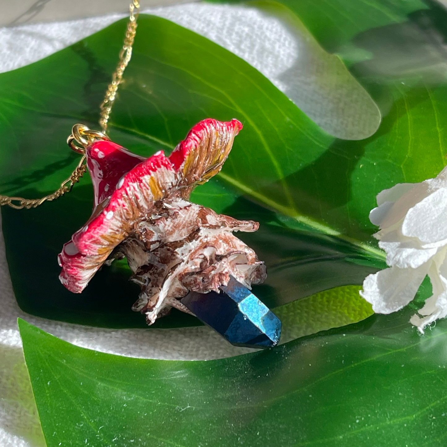 Handcrafted necklace featuring a blue quartz crystal and a polymer clay mushroom pendant, perfect for bohemian and nature-inspired fashion.