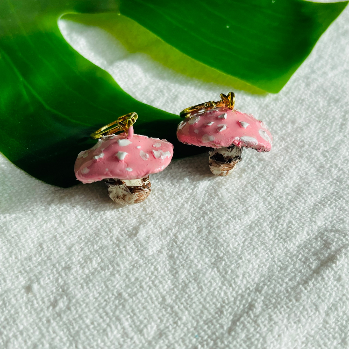 Handmade Enchanted Fungi Earrings featuring intricately hand-sculpted pink mushrooms and gold-plated stainless steel attachments, perfect for sensitive ears and celebrating individuality with a whimsical charm.