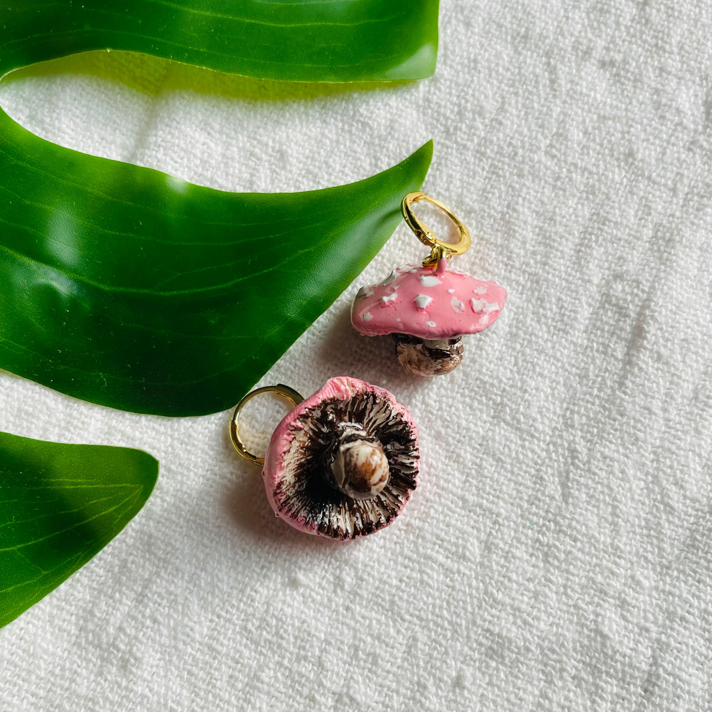 Handmade Enchanted Fungi Earrings featuring intricately hand-sculpted pink mushrooms and gold-plated stainless steel attachments, perfect for sensitive ears and celebrating individuality with a whimsical charm.