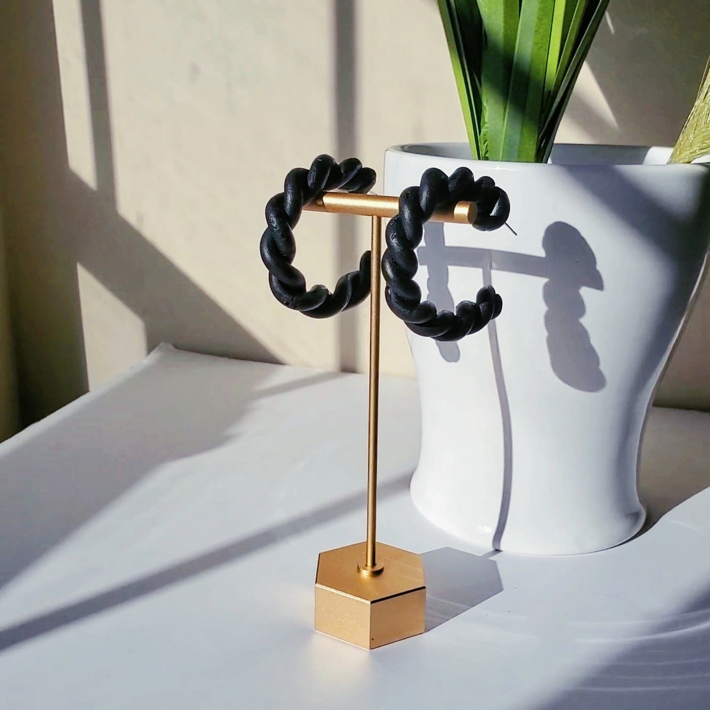 Stylish black polymer clay twisted hoop earrings, perfect for adding a modern touch to any outfit.