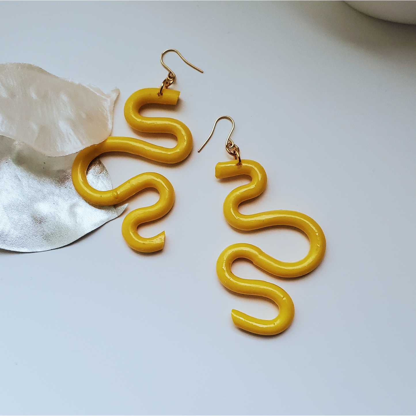 Handmade SELENE Swiggle Earrings crafted from polymer clay, featuring intricate artwork and modern geometric designs, lightweight and waterproof for a bold and unique accessory statement.