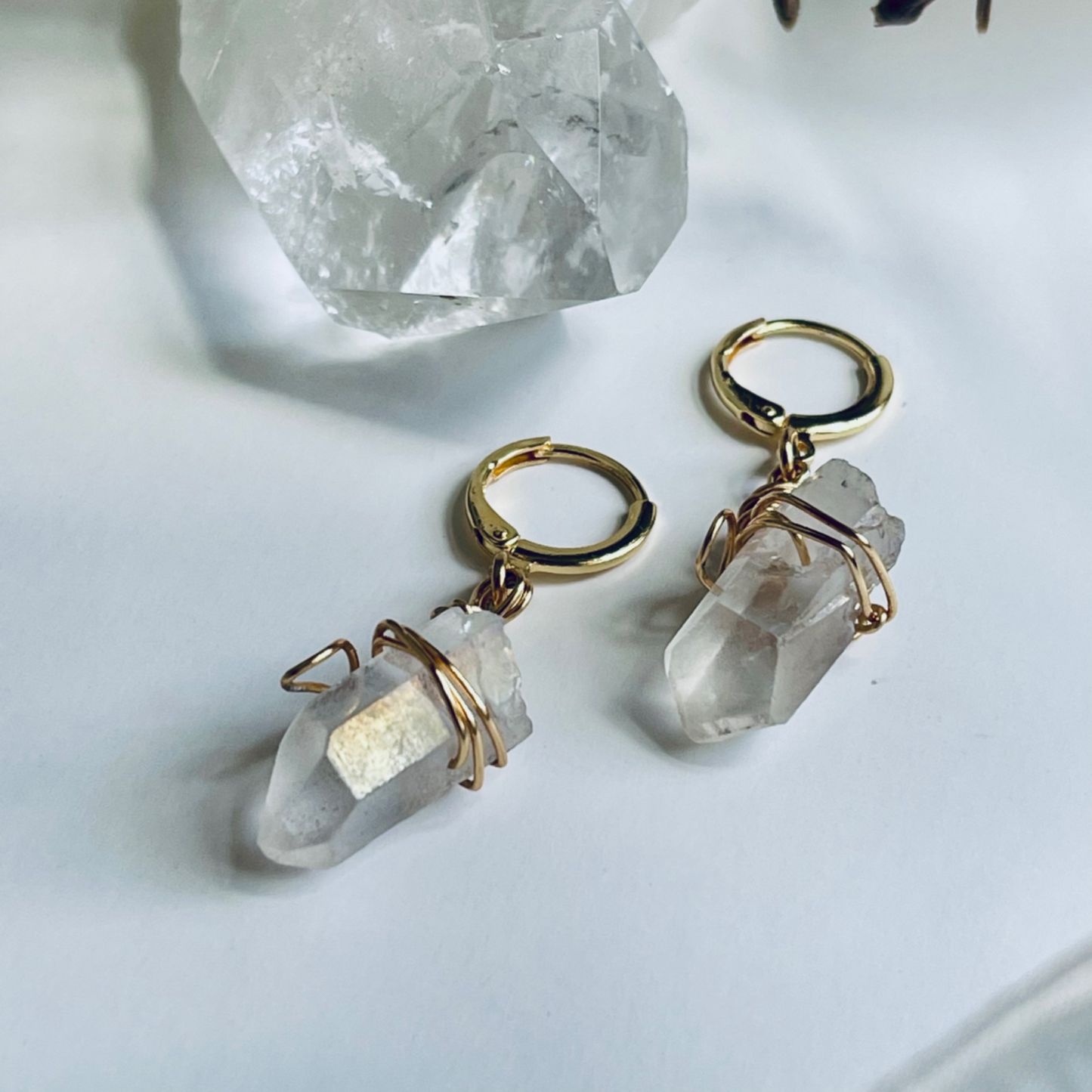 Handcrafted Mini Quartz Hoop Earring featuring a clear quartz gemstone delicately wrapped in 18k gold-plated wire, attached to a lightweight mini hoop. Perfect for layering or wearing alone, this unique piece embodies the properties of clarity and healing.