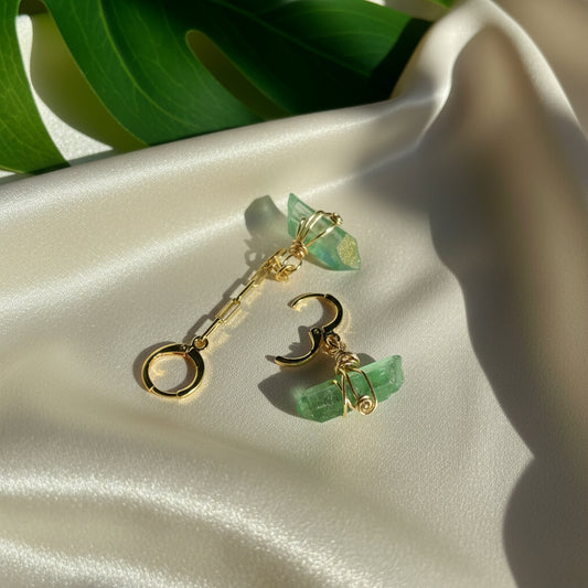 Handcrafted Aria Asymmetric Dangle Earring featuring a captivating Green Quartz crystal. Lightweight and lead/nickel-free, this unique piece adds elegance and boldness to any style.